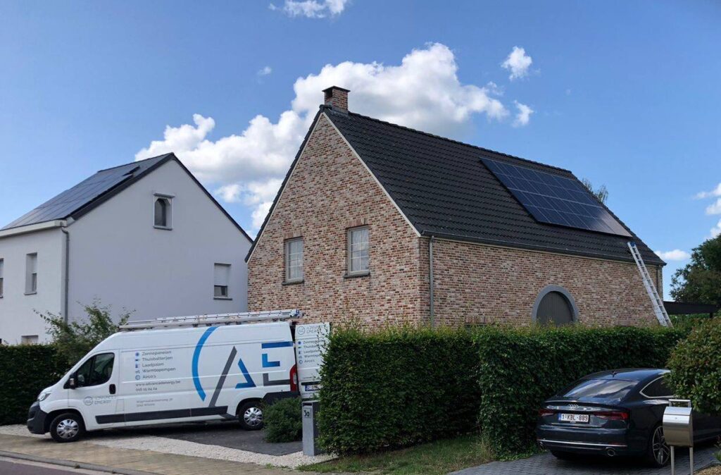 Bestelwagen van Advanced Energy voor een bakstenen woning met zwarte zonnepanelen op het hellende pannendak